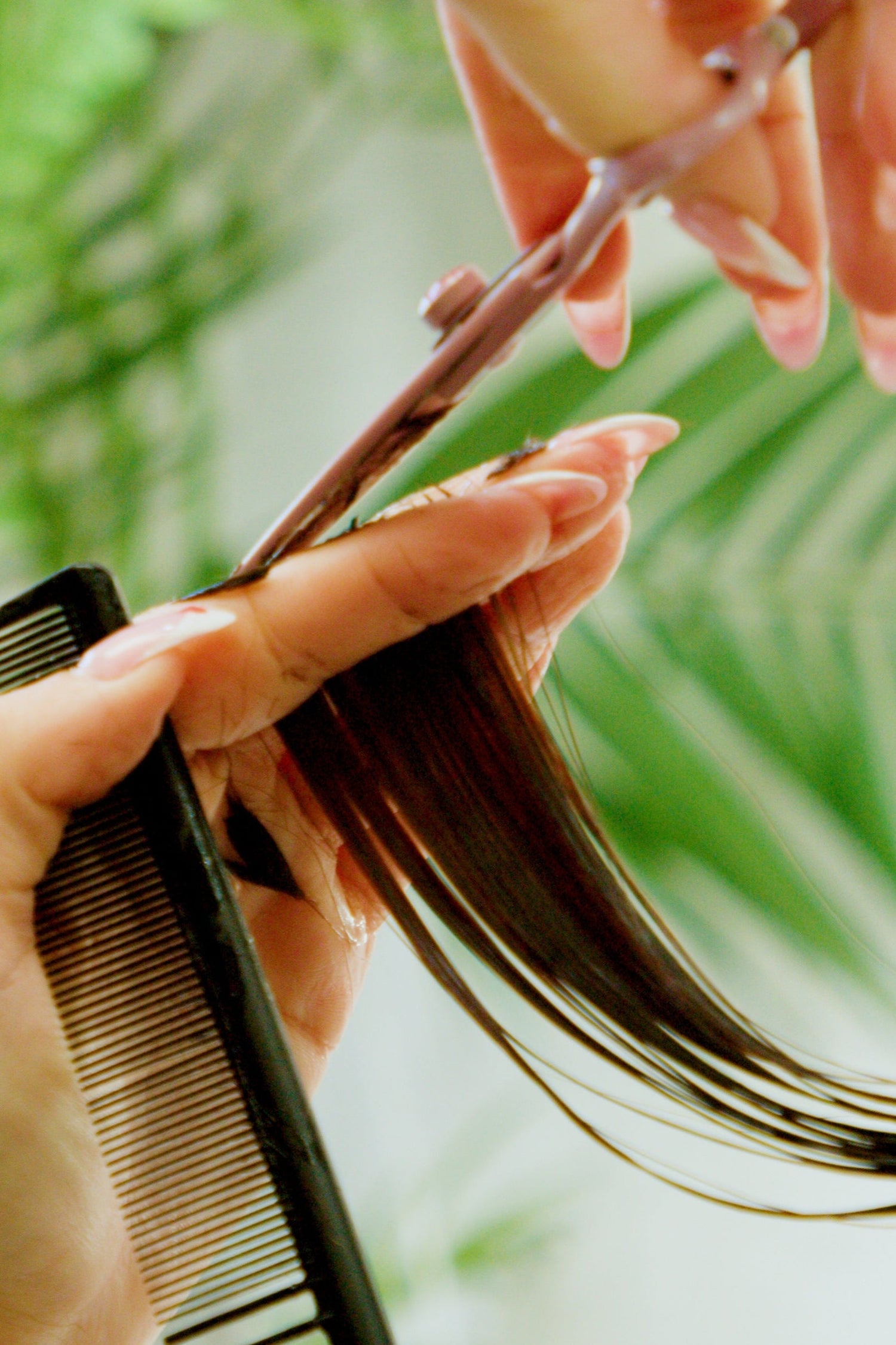 Close-up of a professional hair stylist performing a precise haircut at PHE Salon in Jupiter, FL. The image captures the stylist’s attention to detail and expert technique, reflecting the salon’s high standards in hair cutting and styling services. PHE Salon specializes in personalized haircuts, hair coloring, and beauty services for clients seeking top-tier results in a relaxing environment.